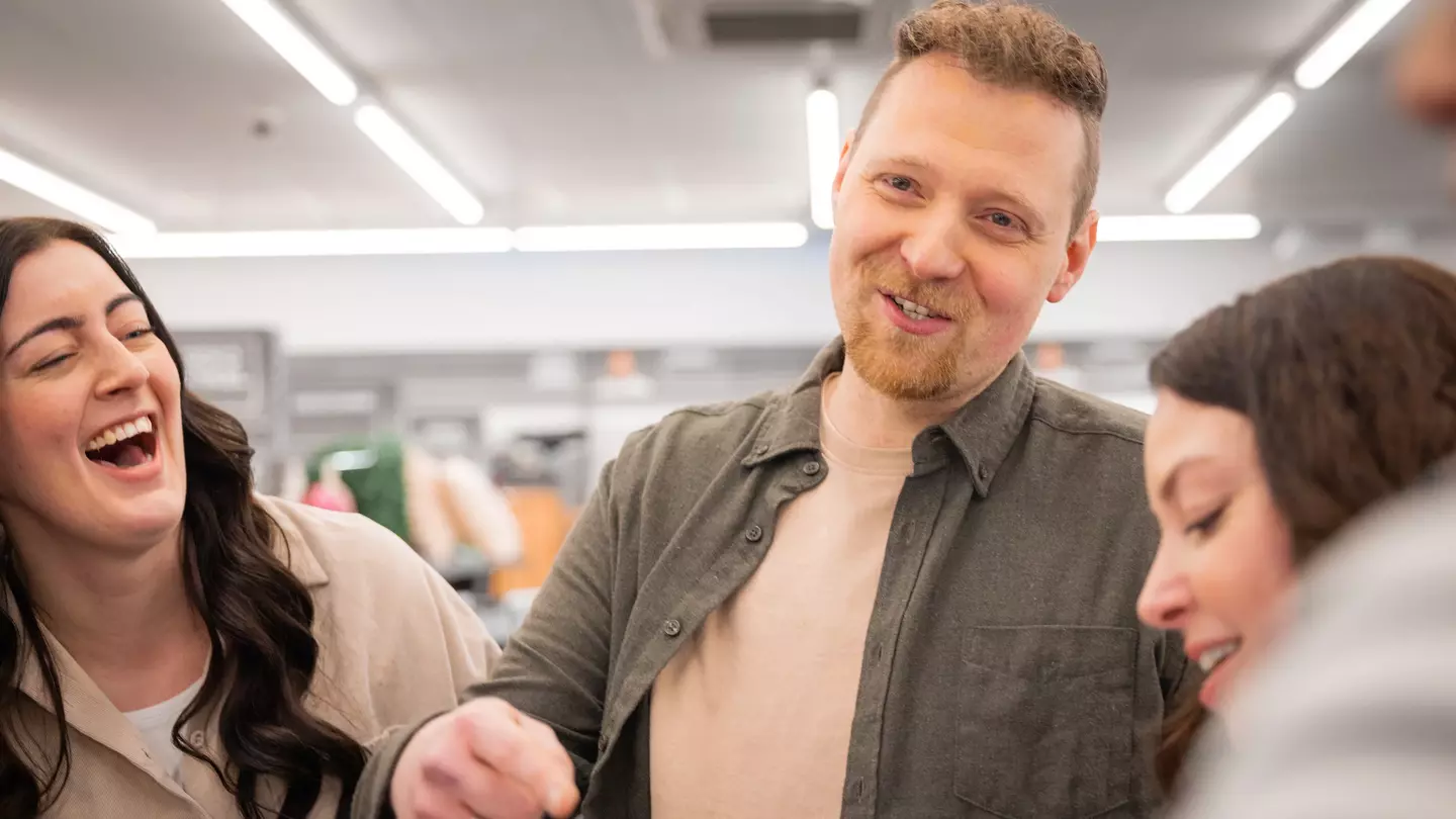 A munkatársak együtt nevetnek egy megbeszélésen az eladótérben.