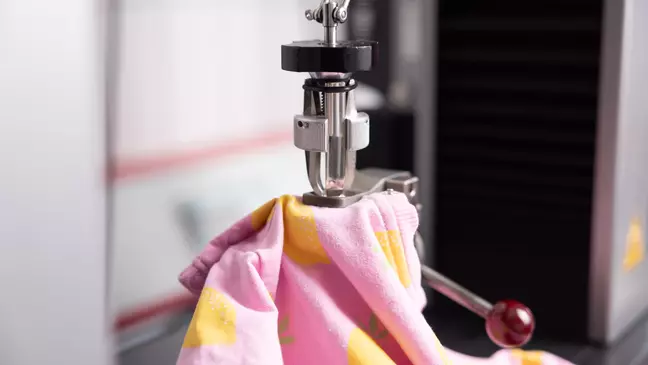 A KiK választékából származó felsőruha a laboratóriumi vizsgálat során a KiK minőségirányításának szimbólumaként