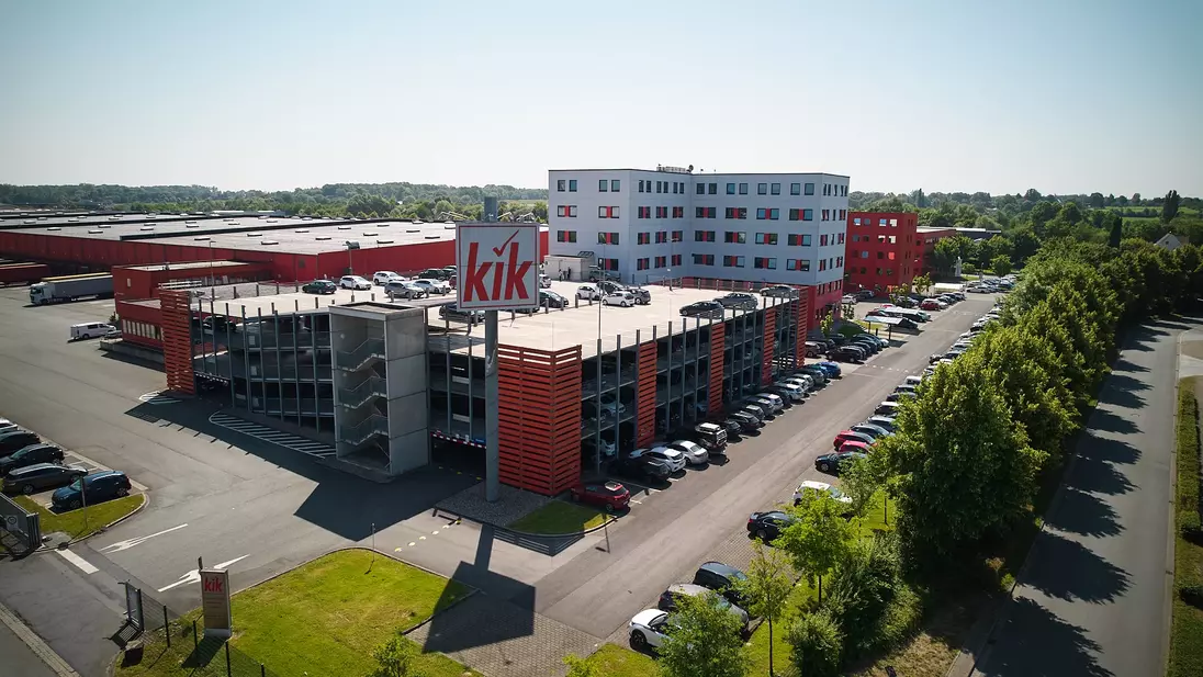 A KiK épületének külső képe, parkolóházzal.